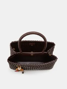 Close-up detail of the dark brown woven leather handbag interior and sturdy top handle.