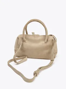 Vue détaillée du sac boston classique en suédine douce avec poignées et sangle.