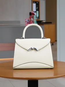 Elegante cremefarbene Handtasche mit speziellem Metall M-Verschluss für den modebewussten Alltag.