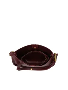 Vue intérieure détaillée du sac en cuir marron avec grande capacité et accessoires dorés.