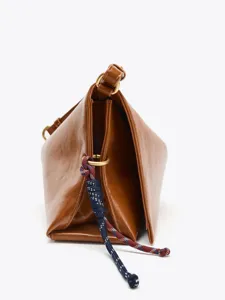 Detail view of brown leather geometric puzzle shoulder bag with contrast braided rope knot.