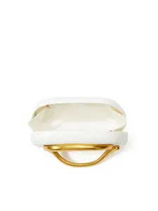Close-up detail of the white hard-shell clutch bag with unique gold metallic handle.
