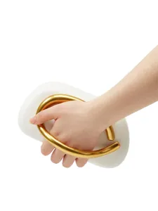 Detailed view of the unique white clutch bag with a luxury gold metallic handle design.