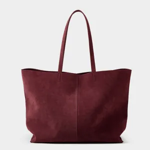 Burgundy suede tote bag detail showing grain texture and long shoulder straps for daily work
