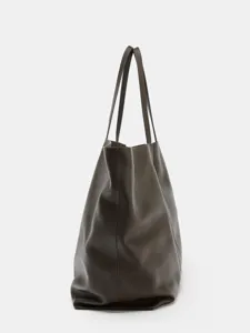 Close-up detail of dark brown leather tote bag side profile, minimalist everyday accessory.