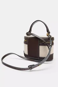 Bolso neceser chic de lona y cuero marrón con asa superior y correa de hombro ajustable.