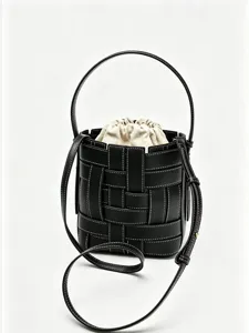 Sac seau en cuir tissé noir avec pochette intérieure beige à cordon et bandoulière.