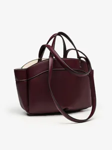 Détail de sac cabas en cuir bordeaux avec poignées structurées et bandoulière élégante.