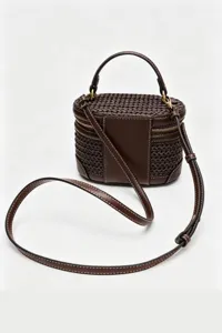 Vista detallada del bolso de hombro marrón de cuero y material tejido elegante chic.