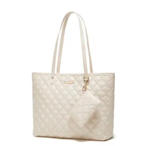 Gros plan montrant la texture matelassée en diamant exquise et les détails dorés du sac blanc.