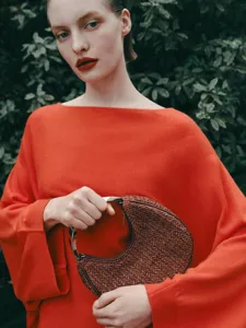 Stylish woven crescent handbag with metal handle, elegant niche design for women.