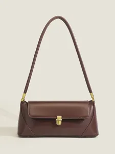 Detail view of the elegant brown leather underarm shoulder bag with golden metal hardware.