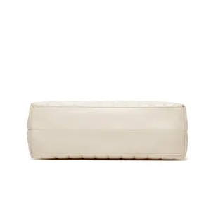 Détails du sac cabas matelassé beige minimaliste, mettant en valeur sa jolie base solide.