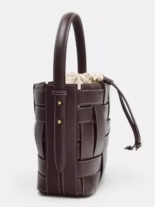 Sac seau en cuir tressé avec poignée supérieure et cordon pour un usage quotidien.
