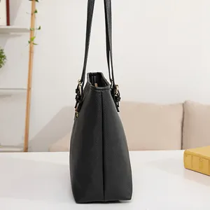 Vista detallada lateral de bolso de mano para mujer en cuero negro texturizado con asas.