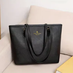 Vista detallada de un elegante bolso tote negro de piel Saffiano con logotipo dorado.