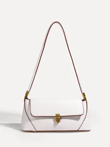 Close-up of white shoulder bag detail showing red contrast edge and brass lock hardware.