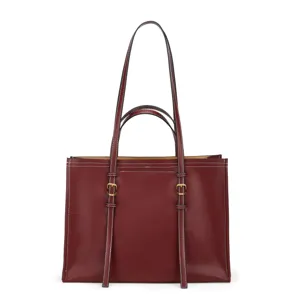 Vue détaillée du sac cabas en cuir bordeaux avec coutures contrastées blanches et boucles dorées.