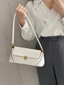 Close-up view of a stylish white shoulder bag with red trim and gold metal clasp.