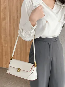 Elegant white retro shoulder underarm bag with red piping and gold hardware for women.