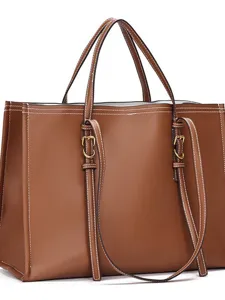 Gros plan détaillé du sac cabas en cuir marron foncé avec de fines surpiqûres blanches.
