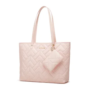 Gros plan sur le sac cabas rose élégant matelassé avec une petite pochette assortie amovible.