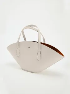 Vue détaillée d'un sac à main en cuir beige en forme d'éventail minimaliste avec doublure marron.