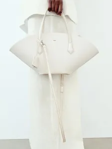Élégant sac à main en cuir beige en forme d'éventail minimaliste avec poignées pour femmes.