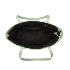 Vue intérieure détaillée du sac cabas vert clair avec doublure noire et poche zippée.