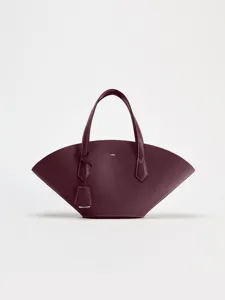 Détail du sac à main en cuir en forme d'éventail avec coutures blanches et finitions métal.