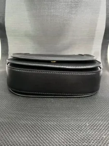 Black leather saddle bag detail view, premium crossbody handbag featuring magnetic snap.