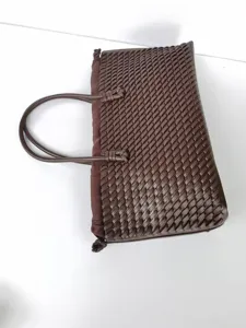 Vista detallada del bolso tote de cuero trenzado marrón oscuro, excelente artesanía fina.