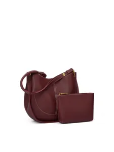 Vue détaillée du sac à épaule bordeaux en cuir avec sa petite pochette assortie présentée.