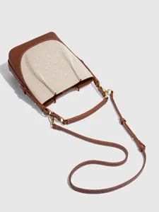 Nahaufnahme, die die Premium-Canvas- und braunen Lederstrukturdetails der Beuteltasche zeigt.