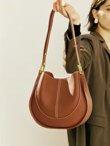 Sac bandoulière marron en cuir souple avec coutures contrastées et quincaillerie.