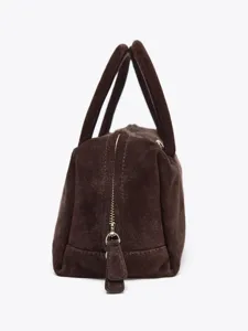 Vue détaillée du sac boston en daim marron foncé avec poignées et fermeture éclair.