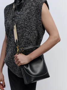 Detailansicht der schwarzen Leder Beuteltasche mit breitem Gurt und weißer Naht.