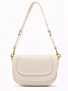 Detailed view of a cream white leather saddle bag featuring contrast stitching and magnetic closure.