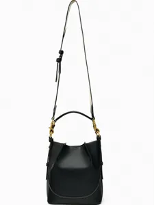 Detailansicht der schwarzen Lederbeuteltasche mit breitem Riemen und goldener Hardware.