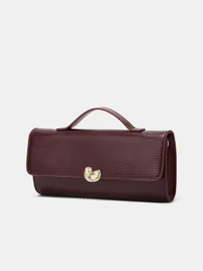 Exquise bordeaux avondtas detail met hagedispatroon en gouden schelpvormige sluiting.
