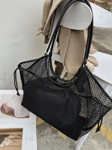 Detailansicht einer grossen schwarzen Mesh Handtasche im klassischen Vintage Pendler Stil.