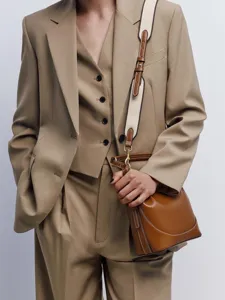 Detailaufnahme einer braunen Damen-Leder-Eimer Tasche mit breitem Canvas-Gurt und Eleganz.