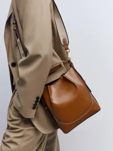 Detailaufnahme der braunen Leder Beuteltasche mit breitem Gurt und elegantem Umhänge-Design.