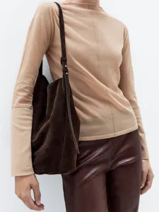 Dettaglio della borsa a spalla in morbido camoscio marrone dal design minimalista e chic.