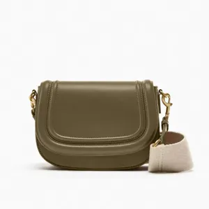 Olive green leather saddle bag for women, stylish crossbody bag with wide strap and flap.