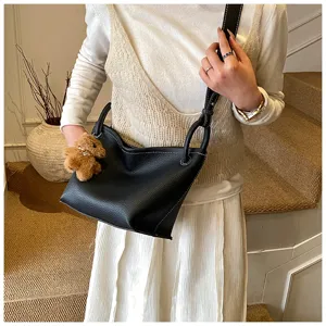 Sac à main en cuir noir avec coutures blanches et charm ours pour le style quotidien