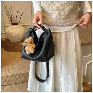 Sac à main seau en cuir noir avec joli pendentif ours sac bandoulière élégant et décontracté.