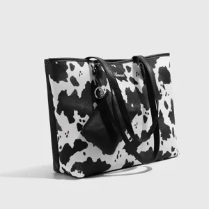 Schicke schwarz-weiße Kuhmuster-Tasche mit kleinen Etui, geräumige Schultertasche für Damen.