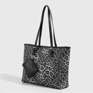 Schwarze und weiße Leo-Print Damentasche mit Schulterriemen und kleiner Beuteltasche.