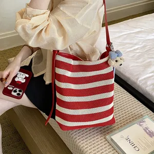 Chic color-blocked striped woven bucket bag, stylish large capacity shoulder crossbody bag.